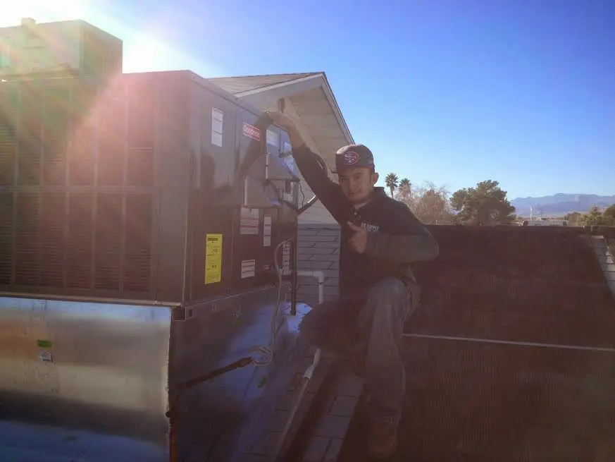 HVAC technician performing Heat Pump Repair on a rooftop unit in Forest